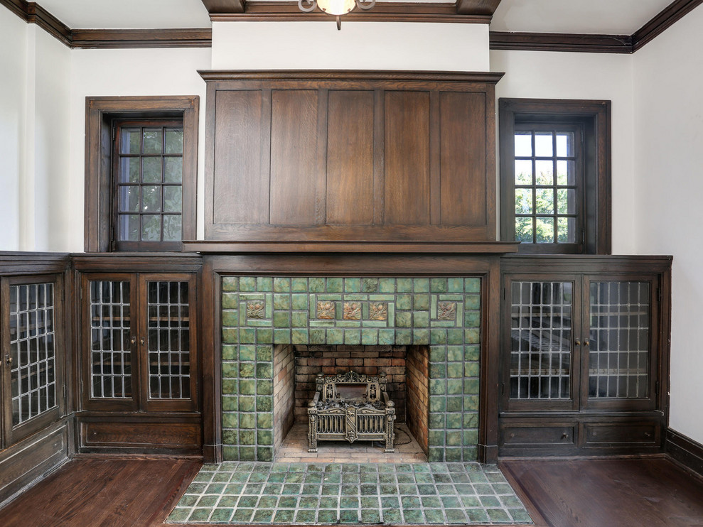 Example of a mid-sized classic enclosed dark wood floor and brown floor living room design in Detroit with white walls, a standard fireplace and a tile fireplace
