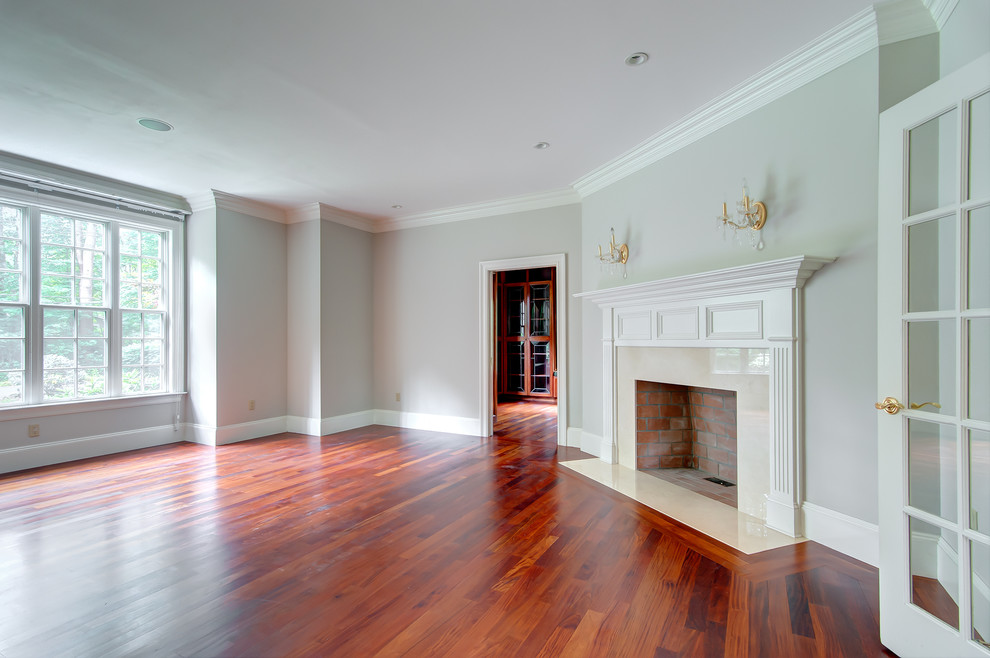 Großes, Repräsentatives, Abgetrenntes Klassisches Wohnzimmer mit grauer Wandfarbe, braunem Holzboden, Kamin und Kaminumrandung aus Holz in Boston