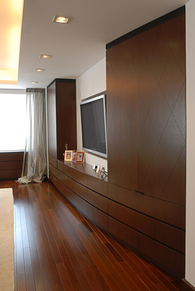 Modelo de salón abierto minimalista grande sin chimenea con paredes blancas, suelo de madera oscura, televisor colgado en la pared y suelo rojo