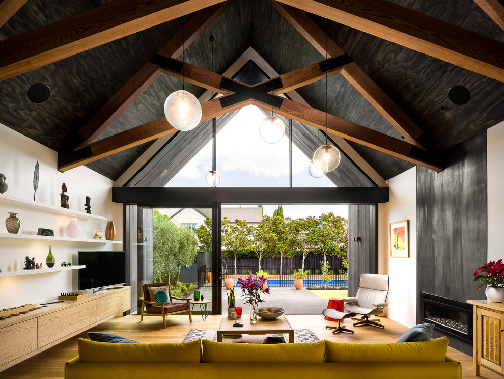 Großes Modernes Wohnzimmer mit weißer Wandfarbe, Kaminumrandung aus Metall, freistehendem TV, beigem Boden, hellem Holzboden und Gaskamin in Christchurch