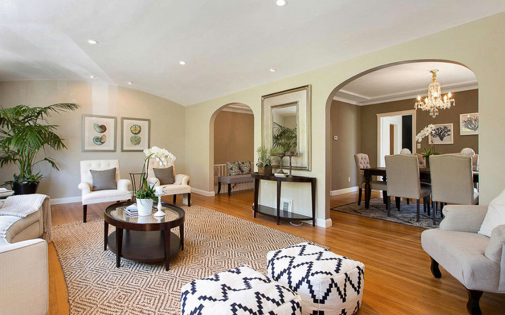 Imagen de salón abierto actual grande con paredes beige y suelo de madera clara
