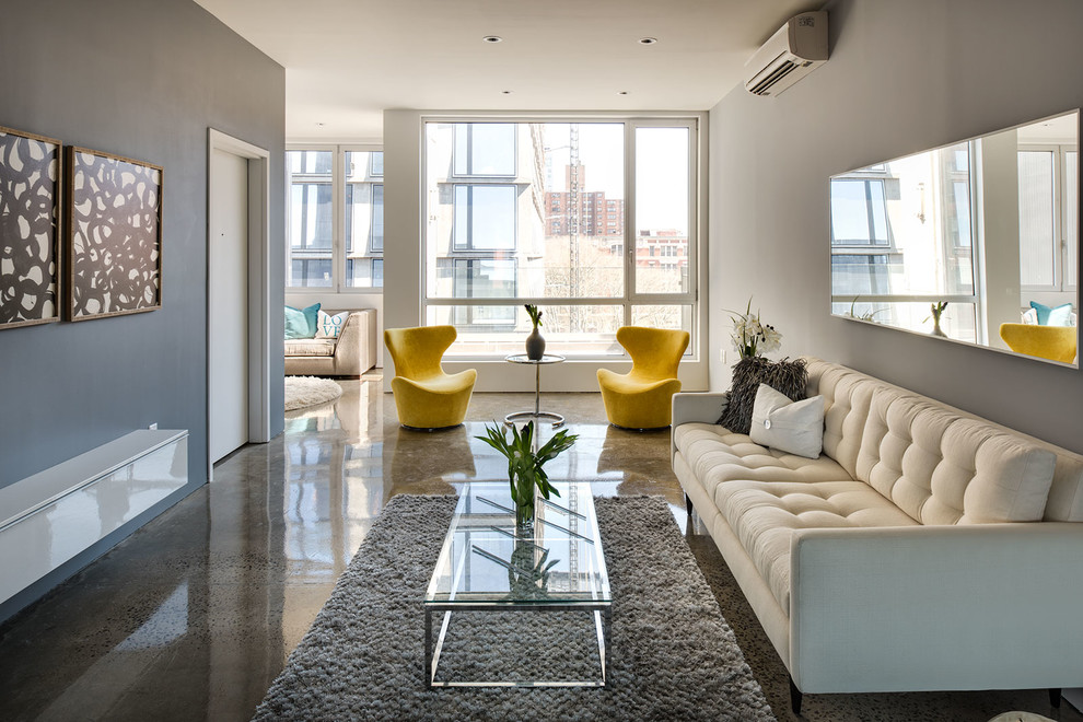 Cette image montre un grand salon design ouvert avec une salle de réception, un mur gris et sol en béton ciré.