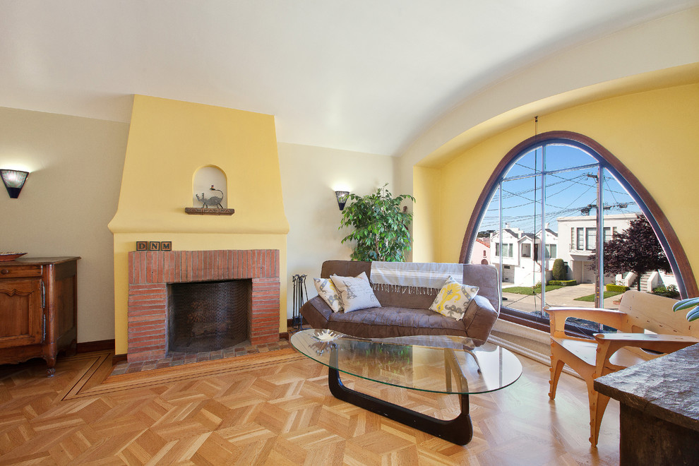Modernes Wohnzimmer mit gelber Wandfarbe, braunem Holzboden, Kamin und Kaminumrandung aus Backstein in San Francisco