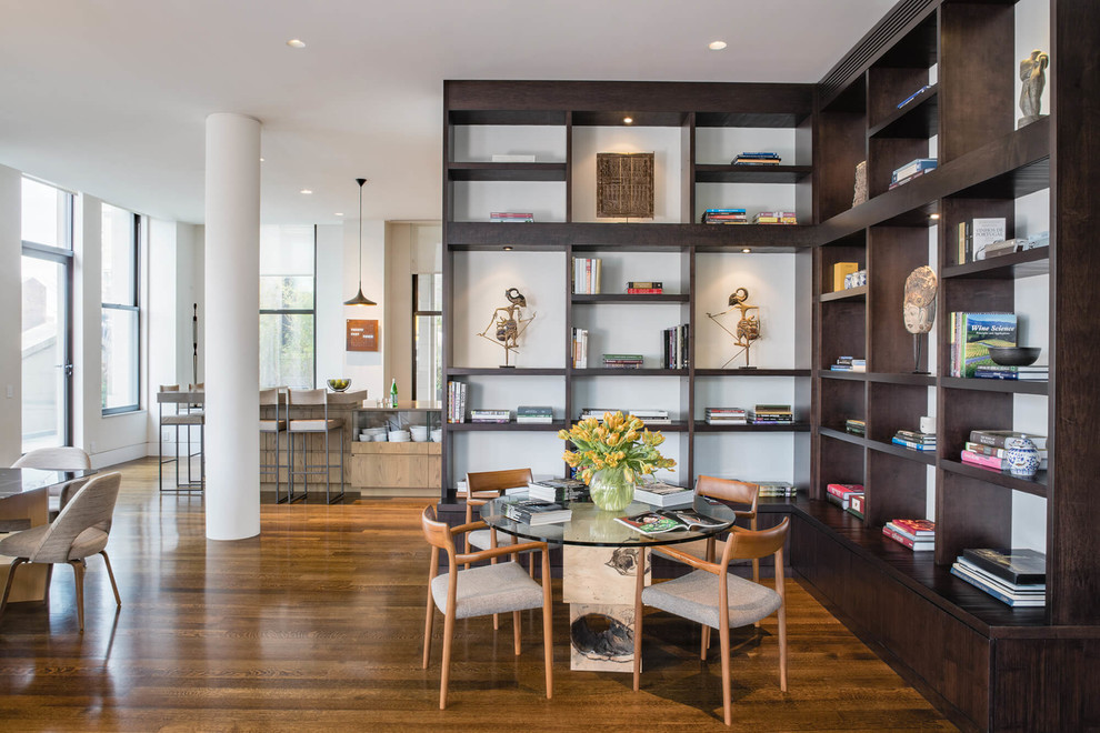 Ispirazione per un grande soggiorno design aperto con libreria, pareti bianche, pavimento marrone e pavimento in legno massello medio