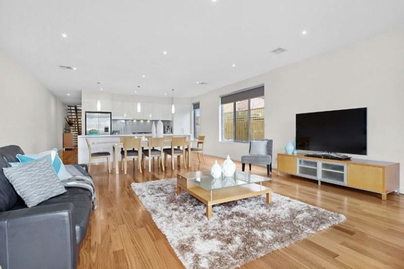 Offenes Modernes Wohnzimmer ohne Kamin mit weißer Wandfarbe, hellem Holzboden und freistehendem TV in Melbourne