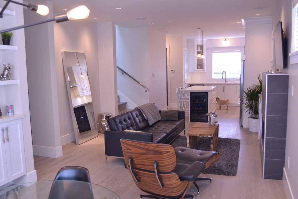 Mittelgroßes, Repräsentatives, Offenes Modernes Wohnzimmer mit beiger Wandfarbe, hellem Holzboden, Kamin, gefliester Kaminumrandung und TV-Wand in Vancouver