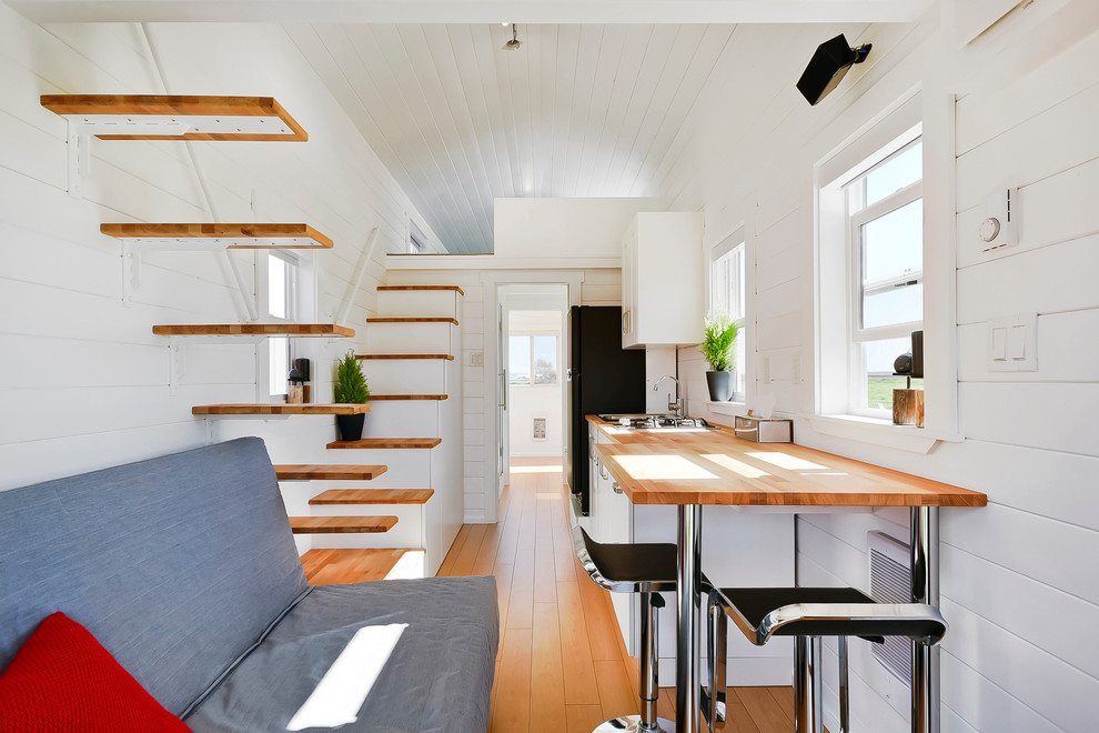 Esempio di un piccolo soggiorno design aperto con pareti bianche e parquet chiaro