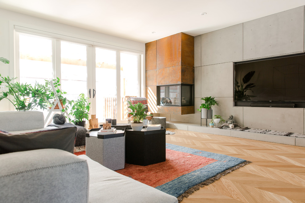 Modernes Wohnzimmer mit grauer Wandfarbe, hellem Holzboden, Eckkamin, Kaminumrandung aus Metall, TV-Wand und beigem Boden in Calgary