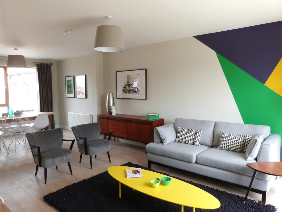 Mittelgroßes, Offenes Stilmix Wohnzimmer mit bunten Wänden, hellem Holzboden und freistehendem TV in Dublin