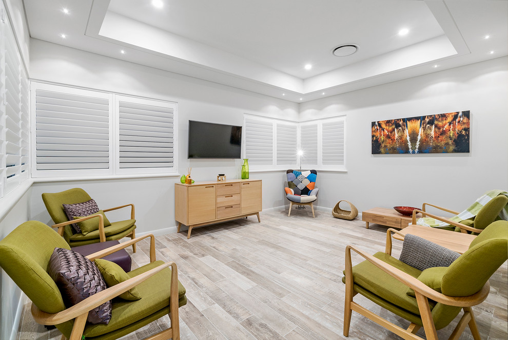 Offenes Maritimes Wohnzimmer mit grauer Wandfarbe, braunem Holzboden, TV-Wand und weißem Boden in Perth
