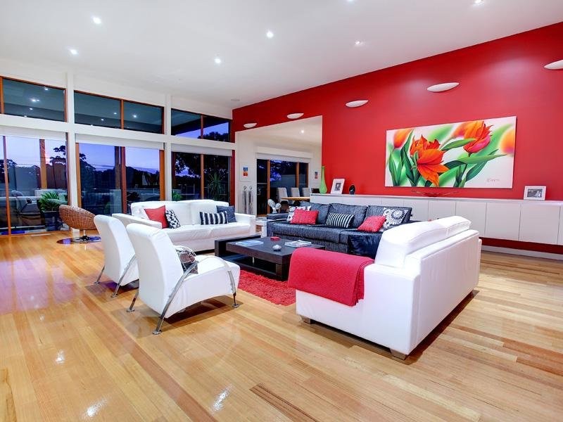 Inspiration pour un salon design avec un mur rouge et parquet clair.