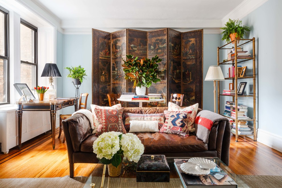 Klassisches Wohnzimmer mit blauer Wandfarbe, braunem Holzboden und braunem Boden in New York