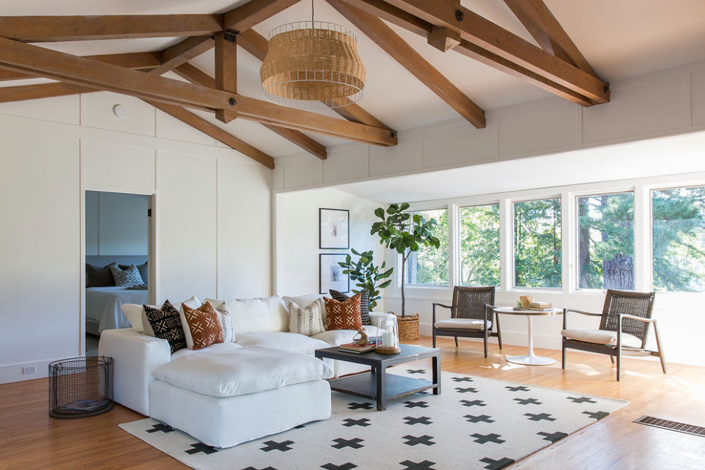 Inspiration for a transitional open concept medium tone wood floor, brown floor, exposed beam and vaulted ceiling living room remodel in San Francisco with white walls
