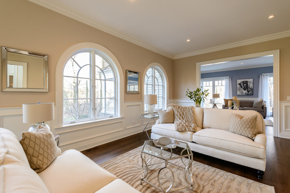 Idee per un soggiorno tradizionale aperto con sala formale, pareti beige e pavimento in legno massello medio