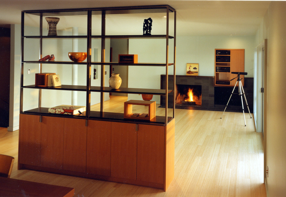 На фото: гостиная комната в стиле модернизм с стандартным камином без телевизора с