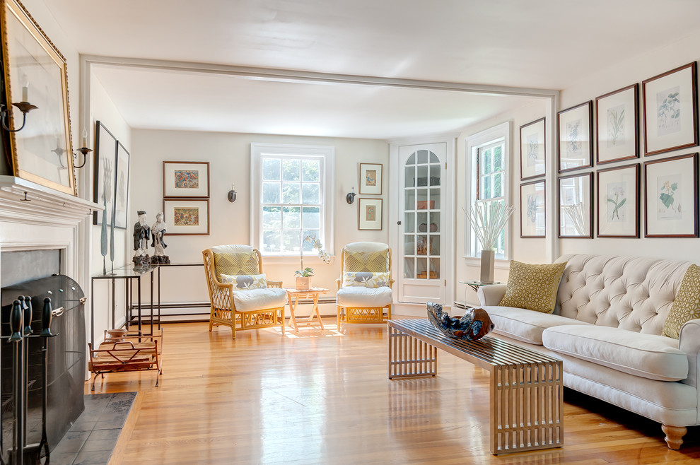 Idée de décoration pour un grand salon tradition fermé avec une salle de réception, un mur blanc, un sol en bois brun, une cheminée standard et un manteau de cheminée en bois.