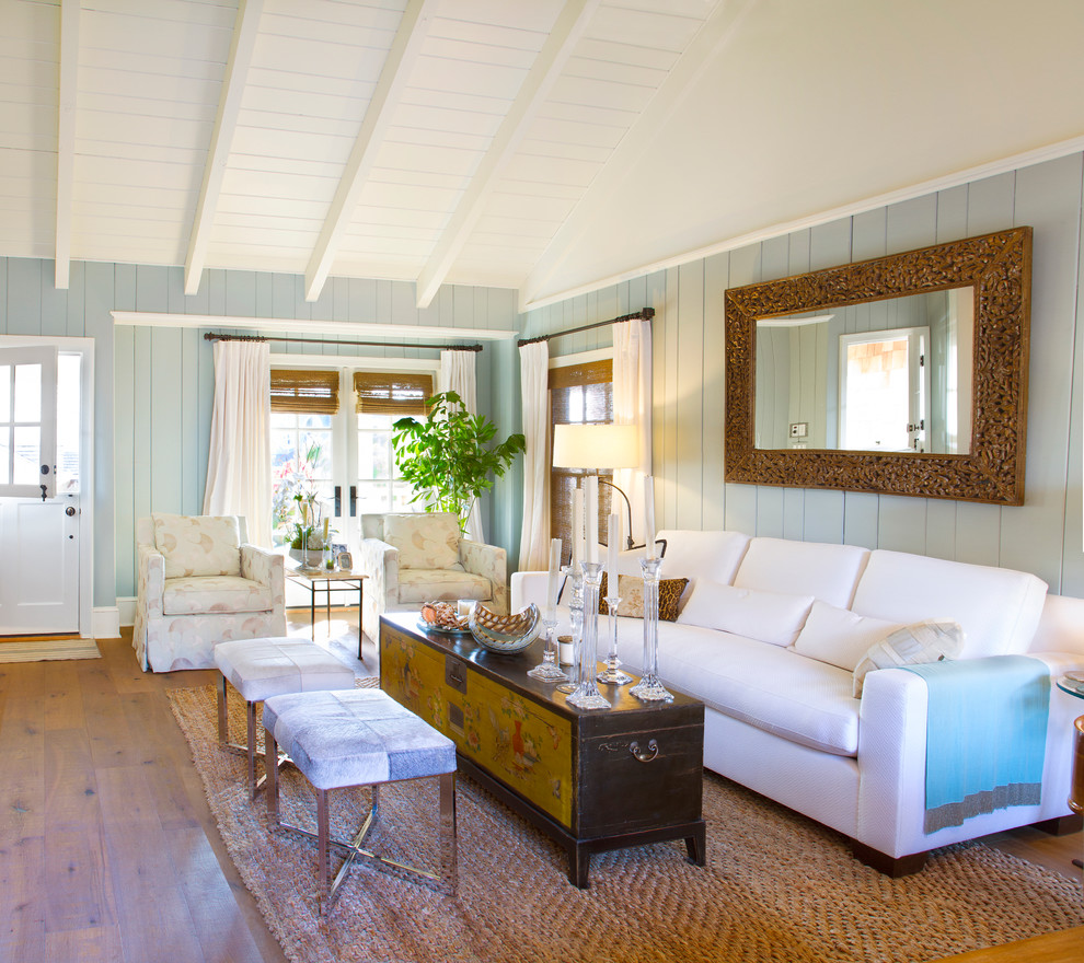 Cette image montre un salon traditionnel de taille moyenne avec un sol en bois brun et un mur bleu.