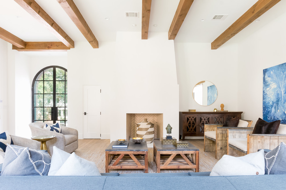 Klassisches Wohnzimmer mit weißer Wandfarbe, hellem Holzboden, Kamin und beigem Boden in Austin