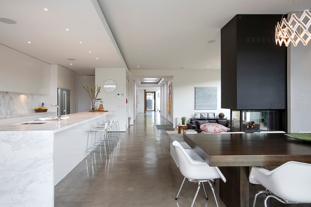 Mittelgroßes, Offenes Modernes Wohnzimmer mit Betonboden und Tunnelkamin in Melbourne