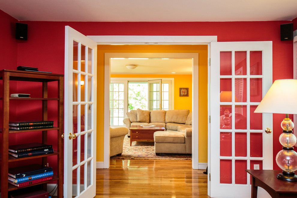 Immagine di un soggiorno classico di medie dimensioni e aperto con pareti gialle, pavimento in legno massello medio e TV autoportante