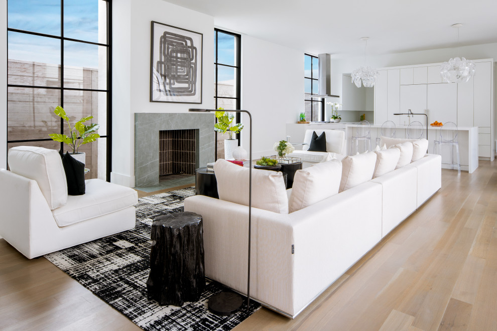 Esempio di un soggiorno contemporaneo aperto con pareti bianche, pavimento in legno massello medio, camino classico e pavimento marrone