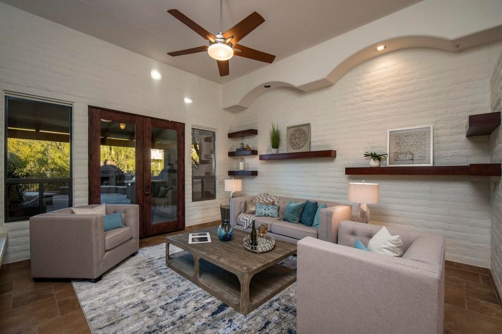 This is an example of a medium sized contemporary formal enclosed living room in Phoenix with beige walls, porcelain flooring, a two-sided fireplace, a brick fireplace surround, no tv and brown floors.