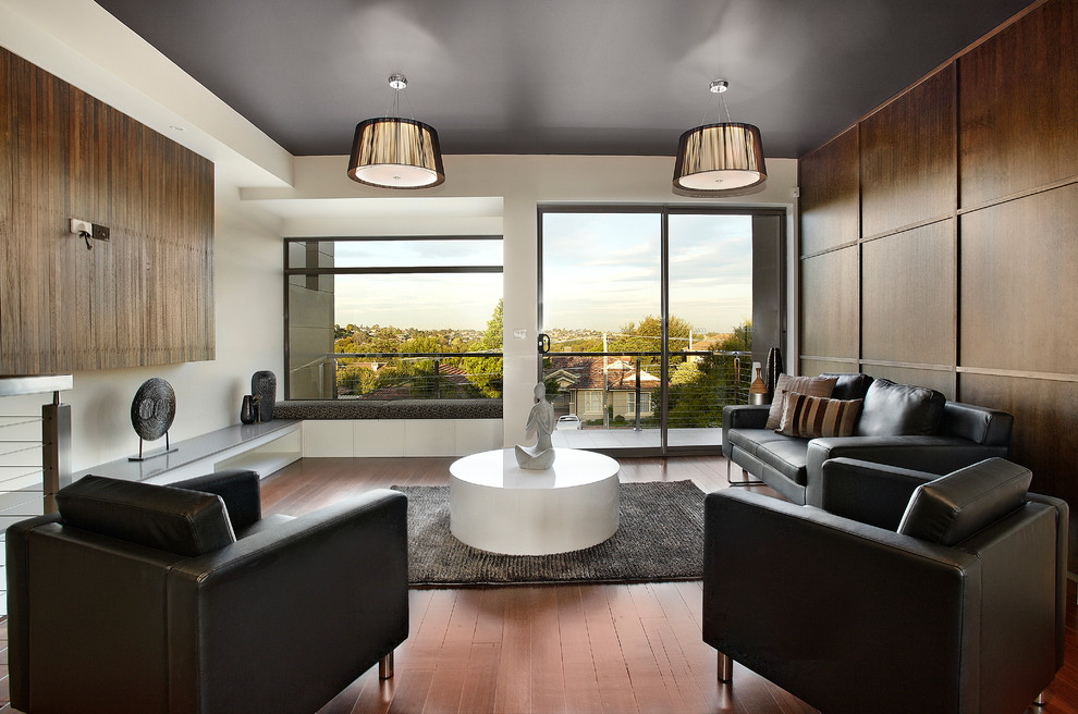 Mid-sized trendy enclosed medium tone wood floor living room photo in Melbourne with white walls and no fireplace