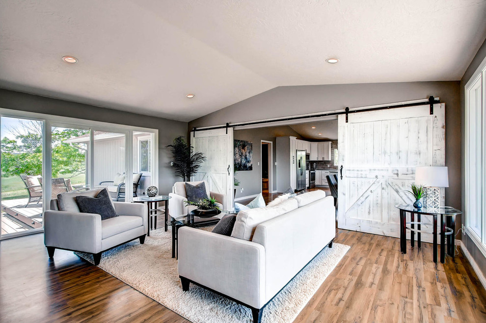 Esempio di un grande soggiorno design chiuso con pareti grigie e pavimento in legno massello medio