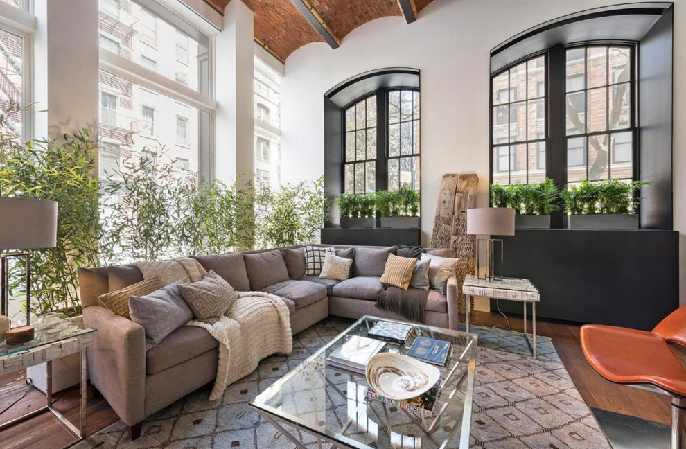 Huge trendy loft-style medium tone wood floor living room photo in New York with white walls