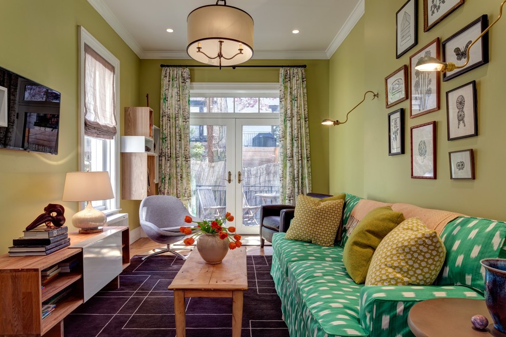 Example of a small classic enclosed medium tone wood floor living room design in New York with green walls, no fireplace and a wall-mounted tv
