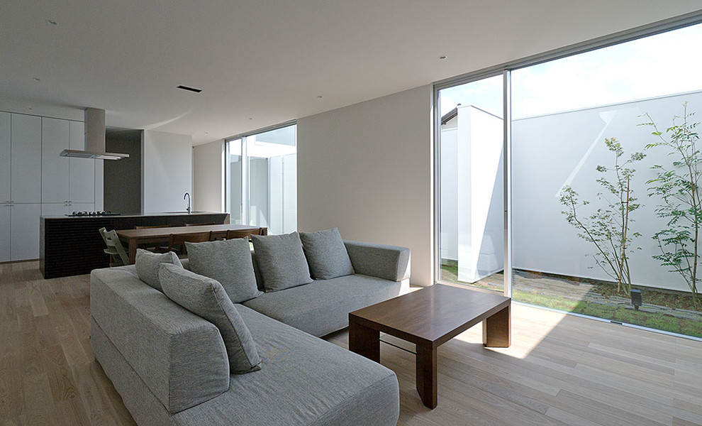 Ispirazione per un soggiorno minimalista di medie dimensioni e aperto con pareti bianche, parquet chiaro e TV autoportante