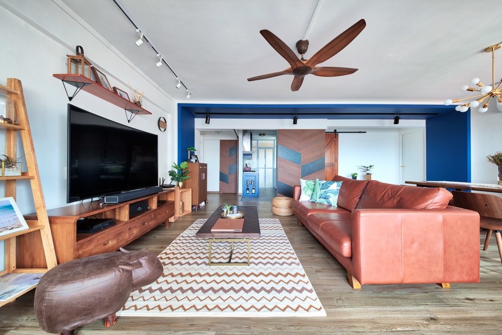 Diseño de sala de estar abierta tradicional renovada sin chimenea con paredes blancas, suelo de madera clara y televisor independiente
