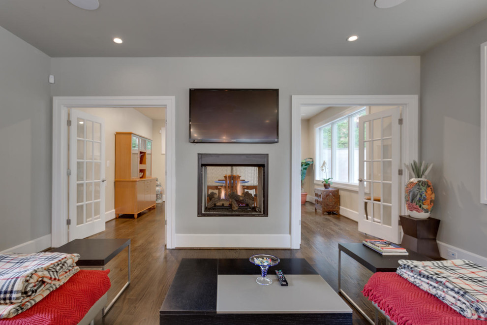 Example of a mid-sized transitional dark wood floor living room design in Orange County with gray walls, a two-sided fireplace, a metal fireplace and a wall-mounted tv