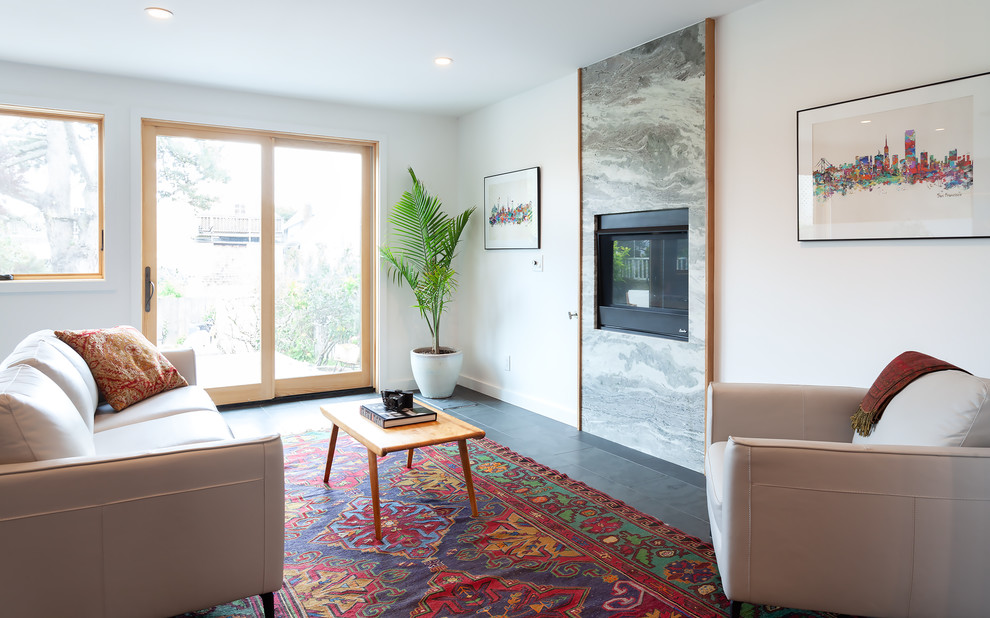 Ispirazione per un soggiorno design con pareti bianche, camino classico e pavimento grigio