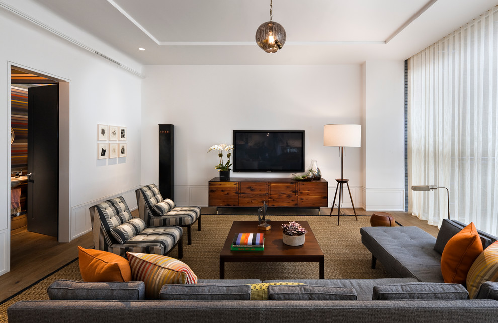 Foto di un soggiorno contemporaneo con pareti bianche, pavimento in legno massello medio, nessun camino e TV a parete