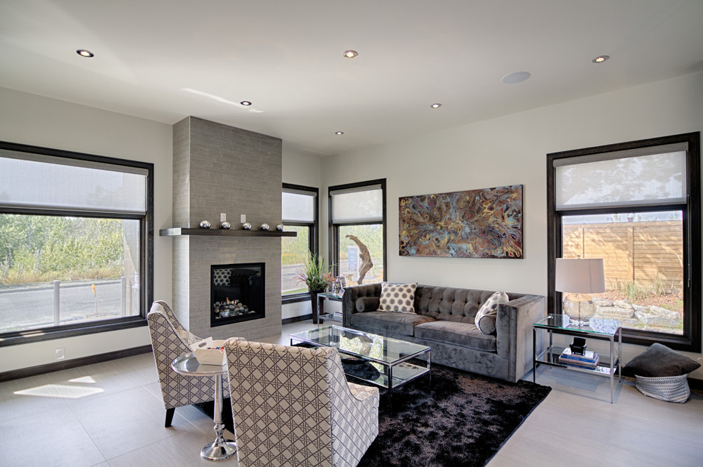 This is an example of a contemporary living room in Calgary with a standard fireplace and a tiled fireplace surround.