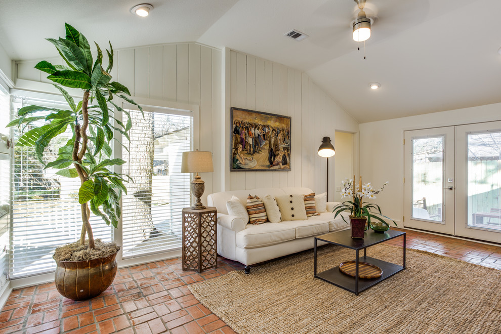 ダラスにある高級な中くらいなカントリー風のおしゃれなリビング (白い壁、テラコッタタイルの床、暖炉なし、据え置き型テレビ、オレンジの床) の写真