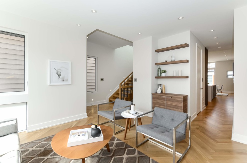 Repräsentatives Nordisches Wohnzimmer ohne Kamin mit weißer Wandfarbe und hellem Holzboden in Toronto