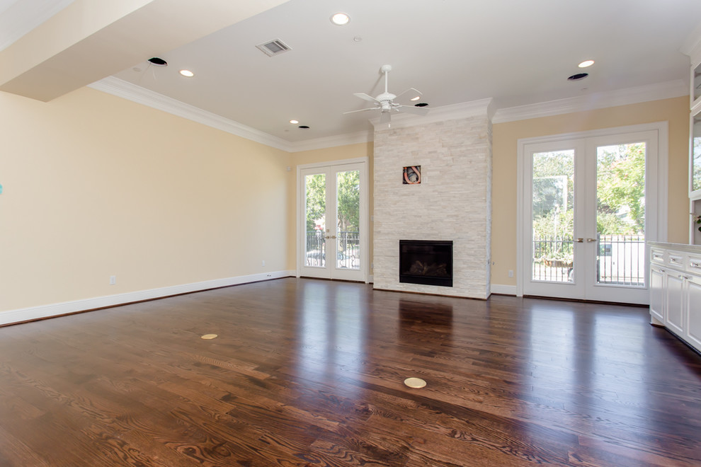 Large mediterranean open plan living room in Houston with beige walls, a standard fireplace, a stone fireplace surround, dark hardwood flooring and brown floors.