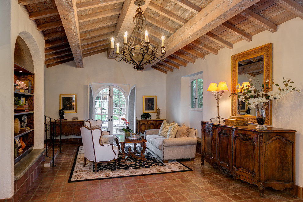 Example of a tuscan terra-cotta tile living room design in Los Angeles with white walls