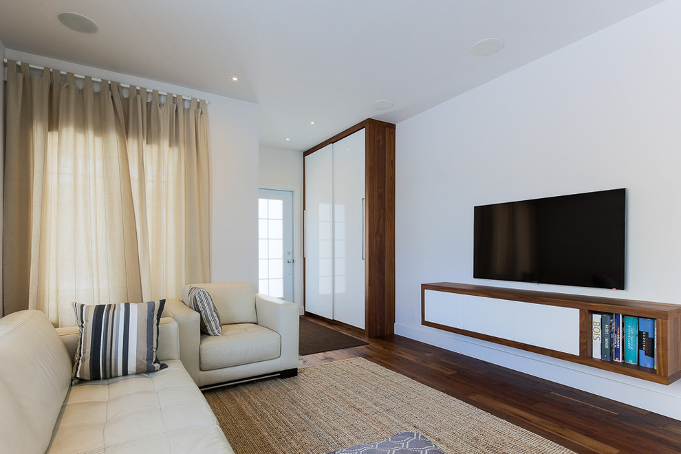 Mittelgroßes, Offenes Modernes Wohnzimmer ohne Kamin mit weißer Wandfarbe, dunklem Holzboden und TV-Wand in Montreal