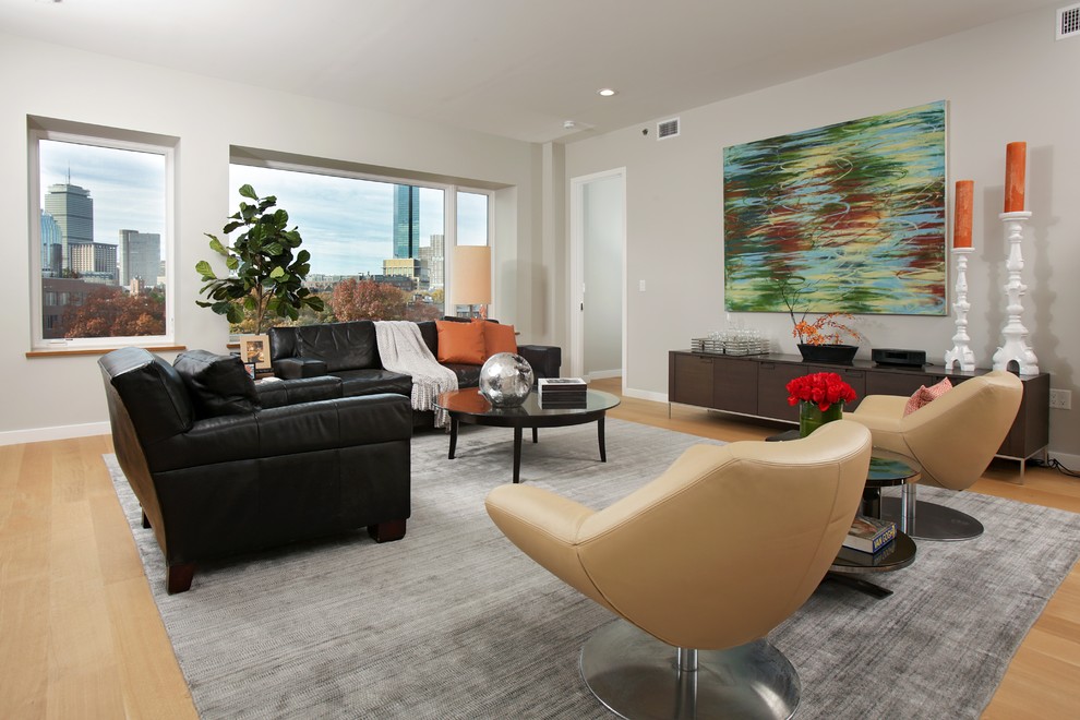 Contemporary living room in Boston with grey walls, light hardwood flooring and no fireplace.