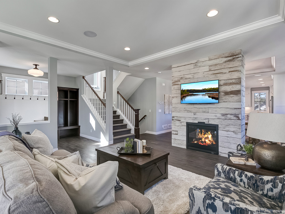 Inspiration for a medium sized traditional formal open plan living room in Minneapolis with grey walls, dark hardwood flooring, a two-sided fireplace, a wooden fireplace surround, a wall mounted tv and grey floors.