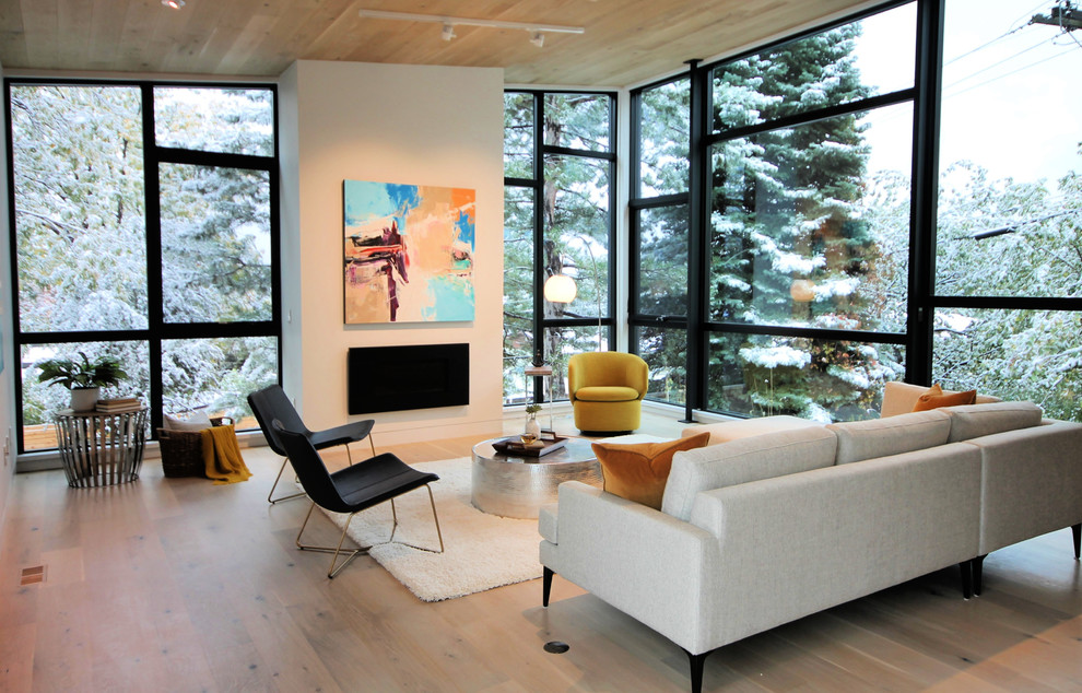 Imagen de salón para visitas abierto actual de tamaño medio sin televisor con paredes blancas, suelo de madera clara, todas las chimeneas y suelo beige