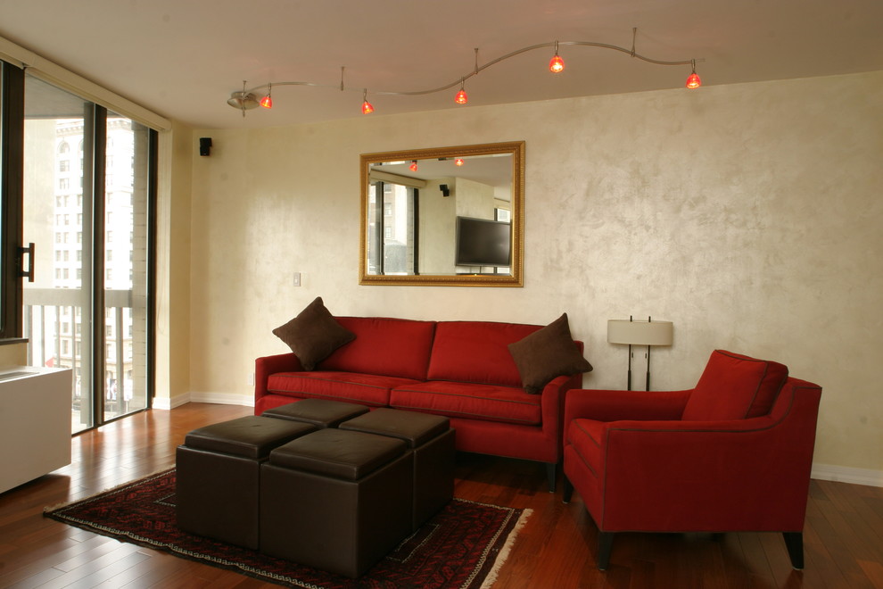 Immagine di un soggiorno tradizionale di medie dimensioni e aperto con pareti beige, pavimento in legno massello medio e TV a parete