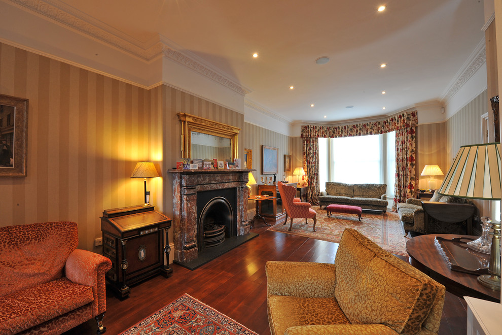 На фото: гостиная комната в стиле неоклассика (современная классика) с стандартным камином и фасадом камина из камня с