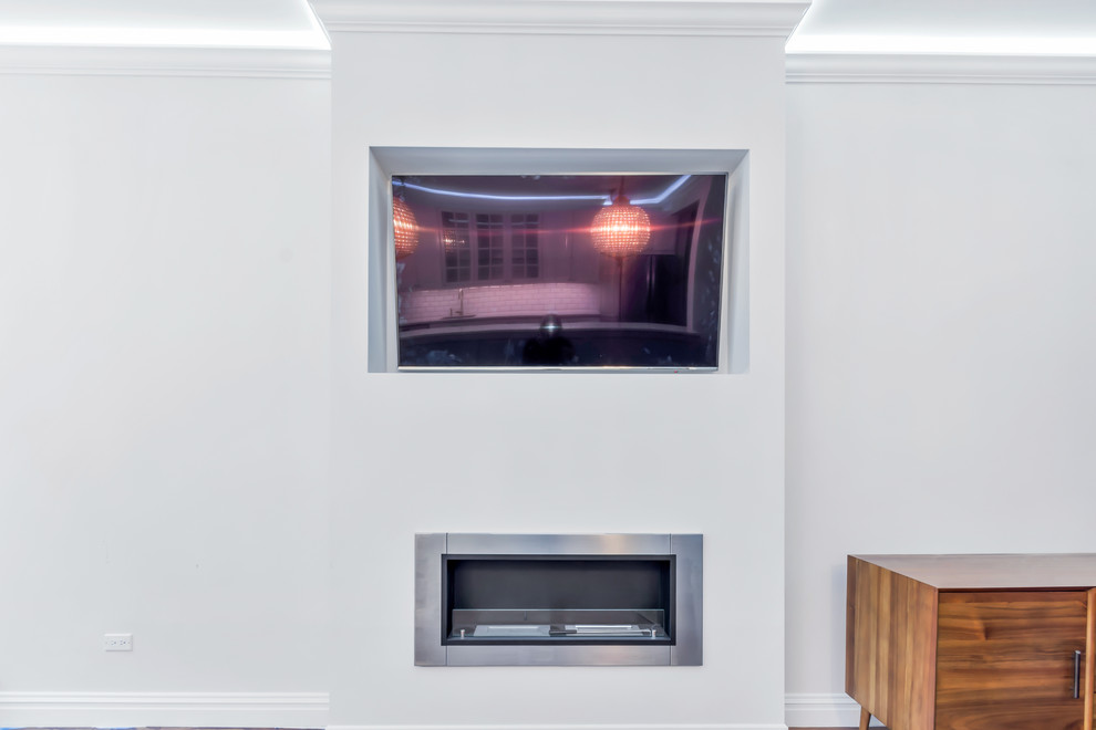 На фото: открытая гостиная комната среднего размера в стиле модернизм с серыми стенами, темным паркетным полом, фасадом камина из штукатурки, мультимедийным центром и горизонтальным камином