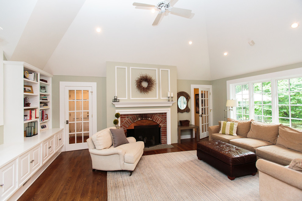 Repräsentatives, Offenes Retro Wohnzimmer mit beiger Wandfarbe, Teppichboden, Kamin und Kaminumrandung aus Backstein in Boston