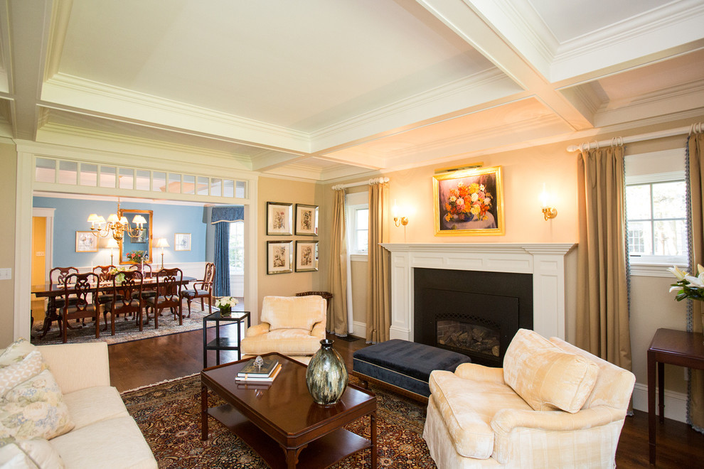 Пример оригинального дизайна: гостиная комната в классическом стиле с желтыми стенами, стандартным камином и фасадом камина из дерева