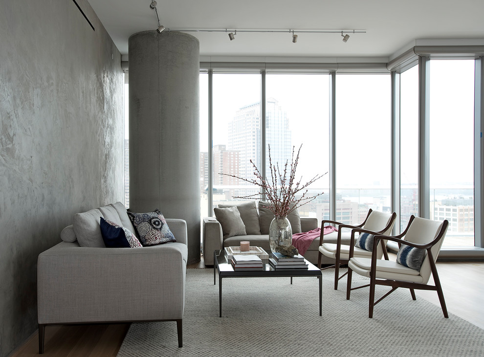 Immagine di un soggiorno design con pareti grigie, pavimento in legno massello medio e pavimento marrone